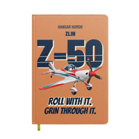 Thumbnail for Zlin Z-50LS - Roll with it. Grin through it. design on orange notebook