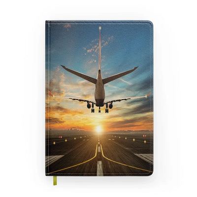 Airplane over Runway Towards the Sunrise aviation design on premium hardcover notebook.