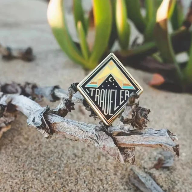 Traveler aviation design on polished metal badge.