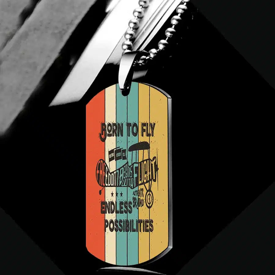 Colourful Born To Fly aviation necklace, polished metal body with engraved detail.