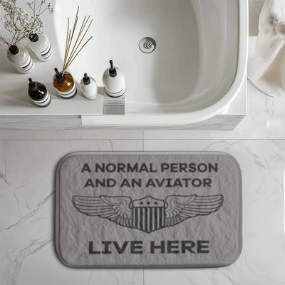 A Normal Person and an AVIATOR Live Here aviation print bath mat, soft absorbent fabric with non-slip backing.