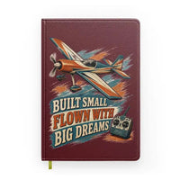 Thumbnail for Built Small Flown With Big Dreams design on dark red notebook