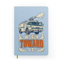 Thumbnail for We Run Toward It design on light blue notebook